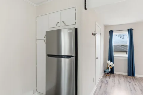 a white refrigerator freezer and a wooden floor
