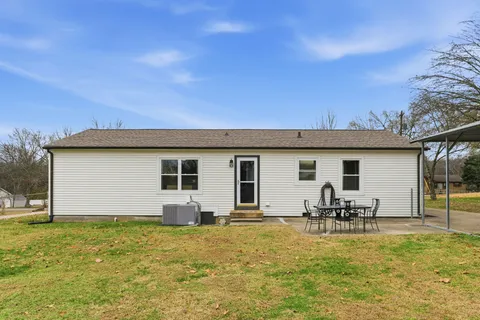 a view of a house with backyard and chairs
