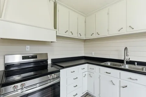 a kitchen with white cabinets and a stove