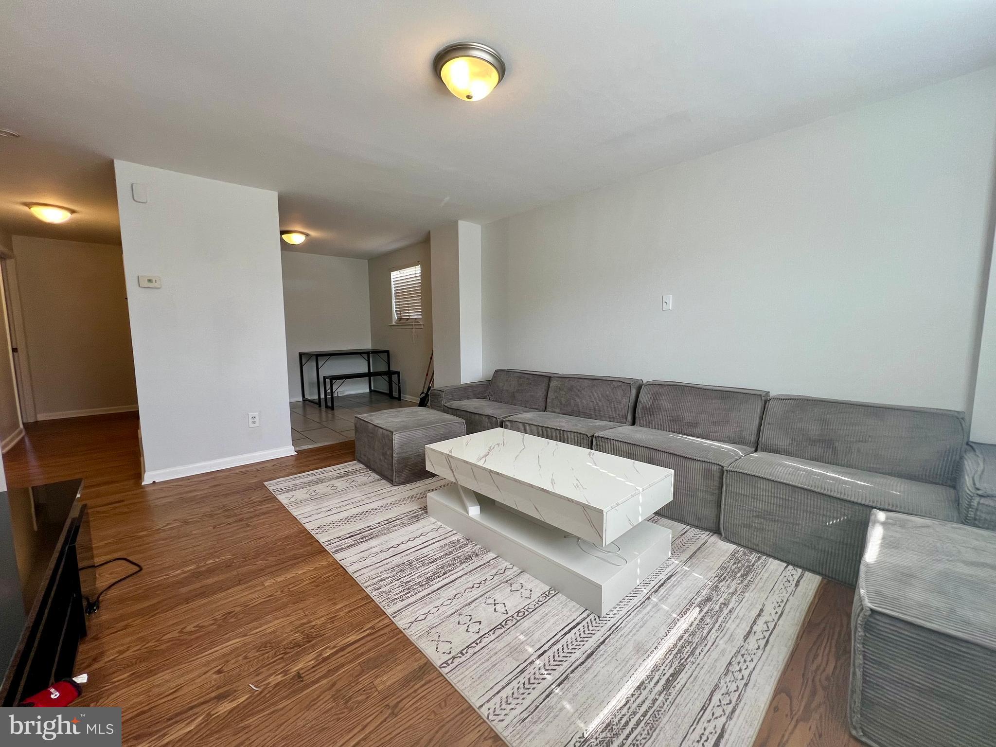 7201 Devon Street, Unit 1 Philadelphia, PA 19119 - Photo 5 of 13 a living room with couches and a flat screen tv