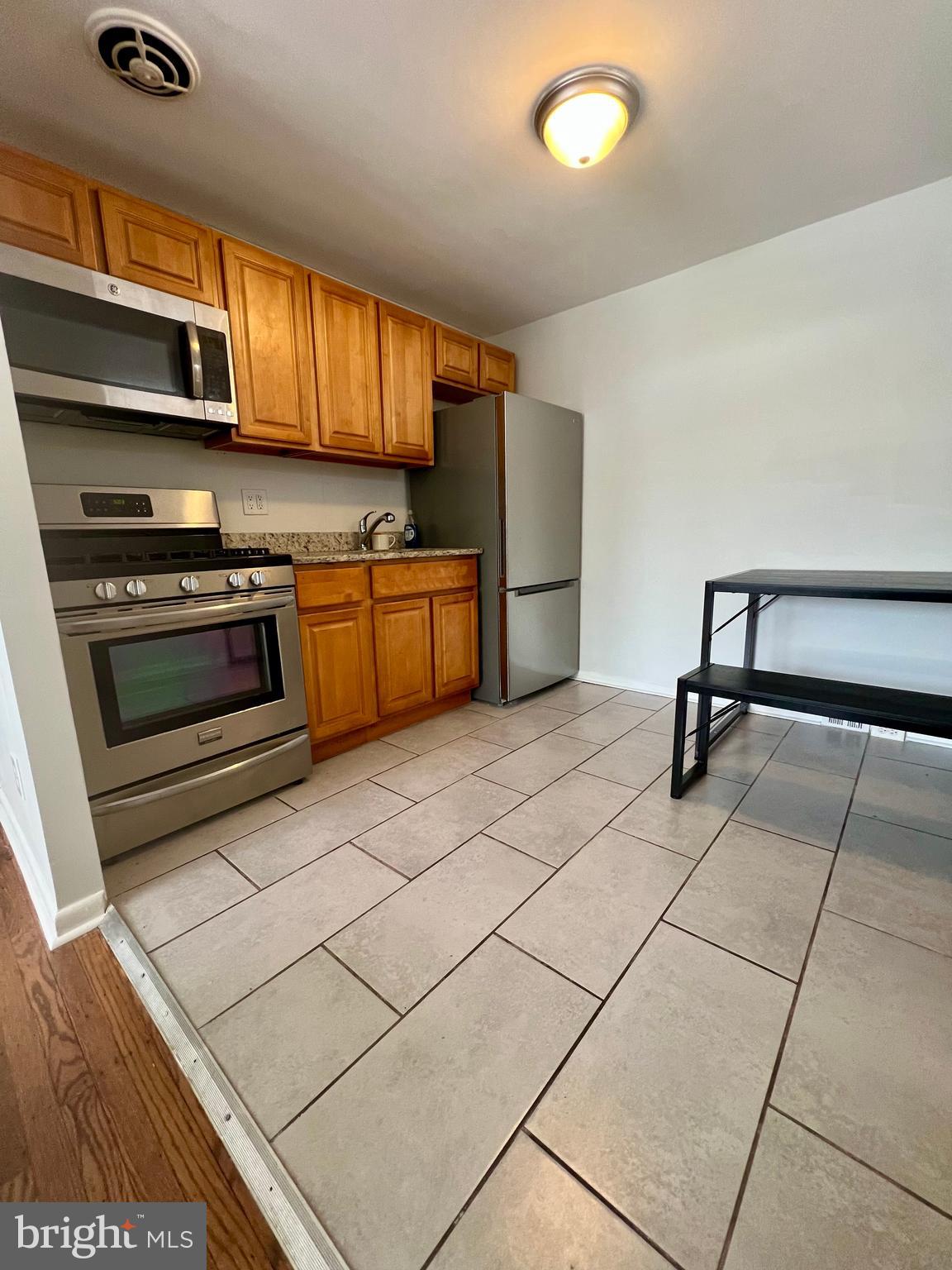 7201 Devon Street, Unit 1 Philadelphia, PA 19119 - Photo 7 of 13 a kitchen with stainless steel appliances a stove a sink and a microwave