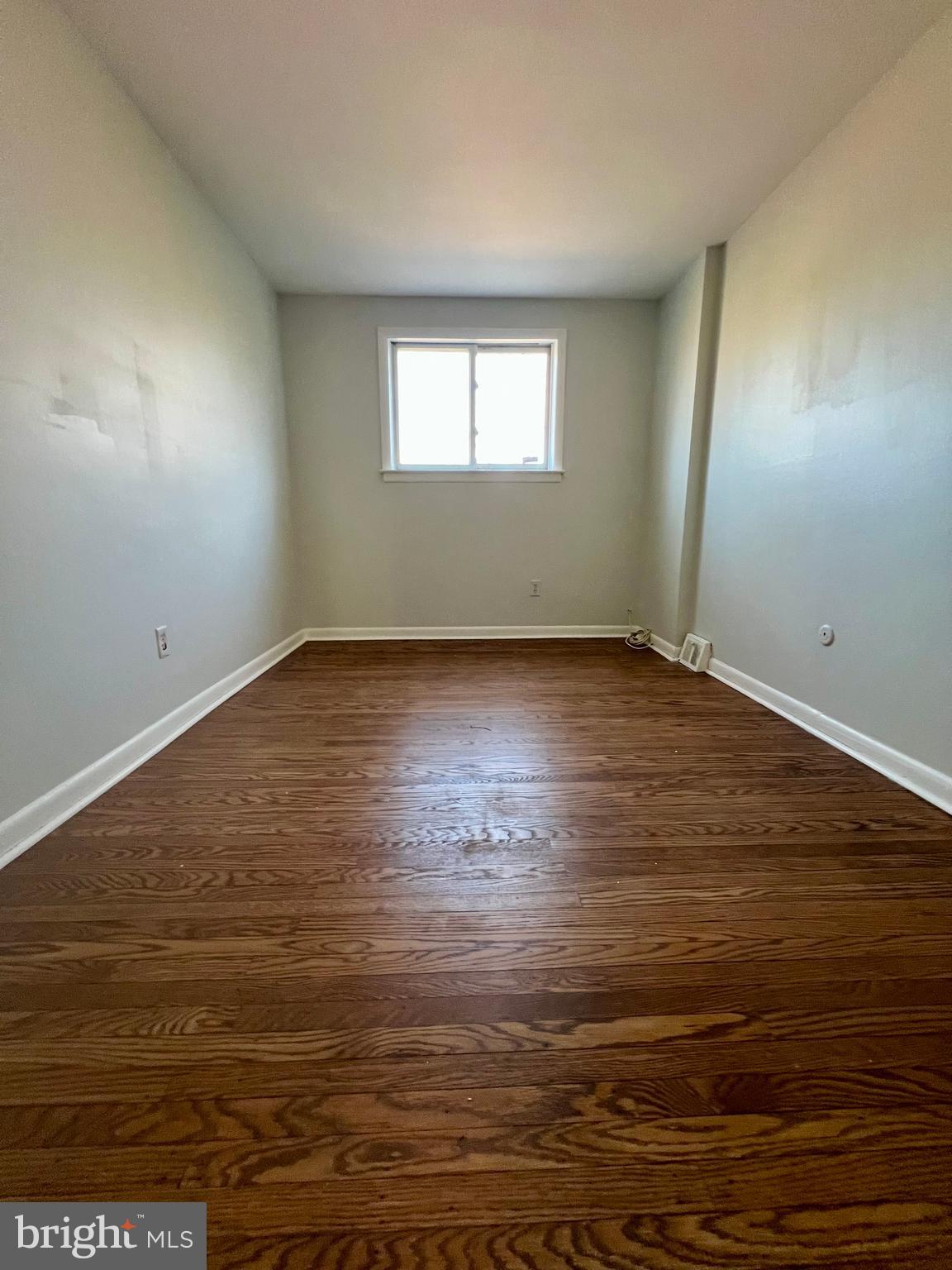 7201 Devon Street, Unit 1 Philadelphia, PA 19119 - Photo 8 of 13 a view of an empty room with wooden floor and a window