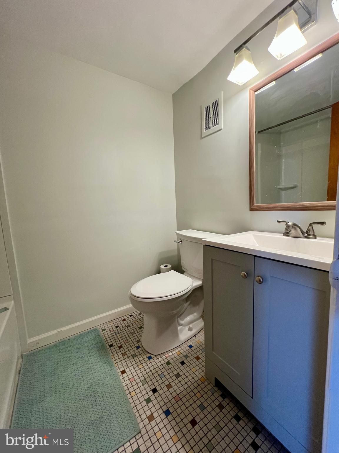 7201 Devon Street, Unit 1 Philadelphia, PA 19119 - Photo 10 of 13 a bathroom with a toilet sink and mirror