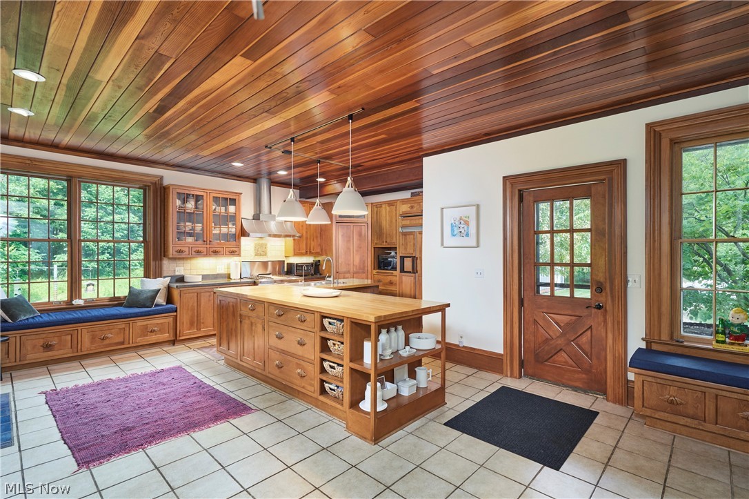 5046 Alger Road Richfield, OH 44286 - Photo 26 of 49 Kitchen featuring a wood-panel ceiling, extensive wood cabinetry, and a central island with integrated storage