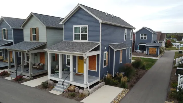 a view of a house with a yard and floor to ceiling windows