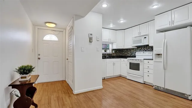 a kitchen with white cabinets and white appliances