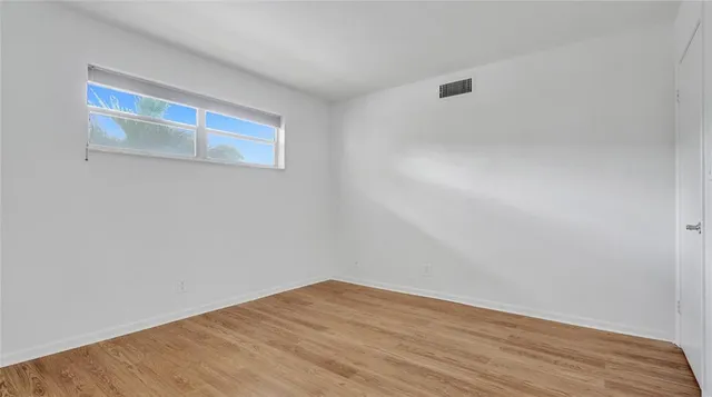 a view of a room with wooden floor and white walls