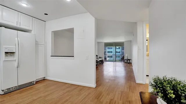 a view of a hallway with wooden floor and a living room