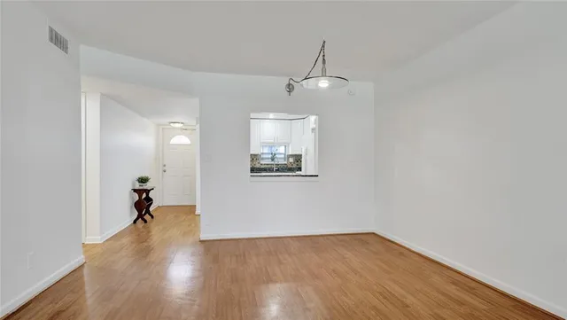 a view of a room with wooden floor staircase and a ceiling fan