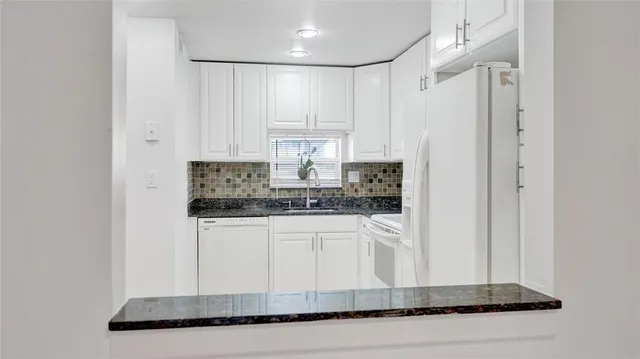 a kitchen with stainless steel appliances granite countertop a sink and a refrigerator