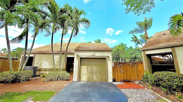 a front view of a house with a yard and potted plants
