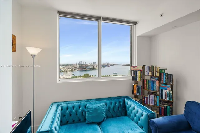 a living room with furniture a bookshelf and a window