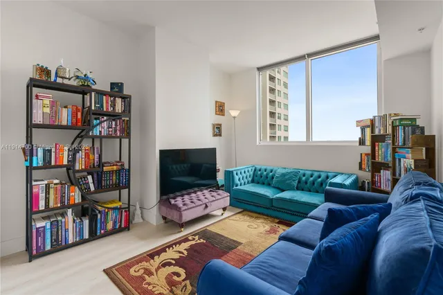 a living room with furniture and a book shelf