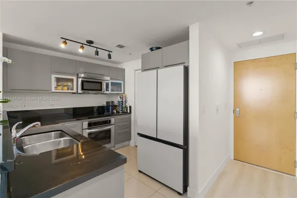 a kitchen that has a refrigerator and a sink