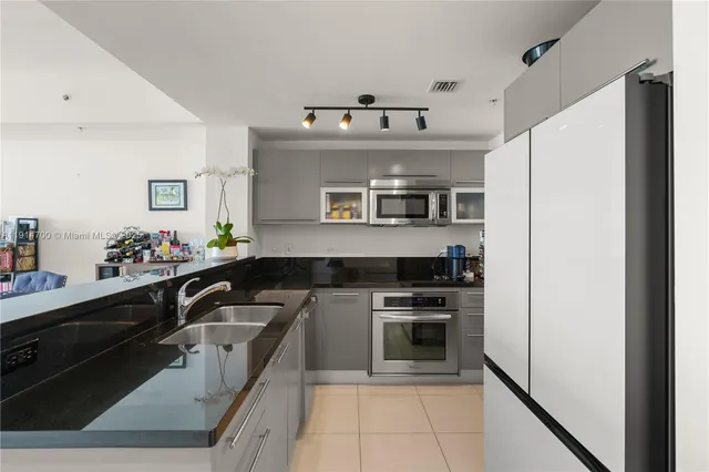 a kitchen with stainless steel appliances granite countertop a refrigerator and a stove