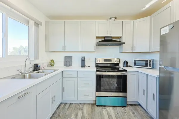a kitchen with cabinets appliances a sink and a window