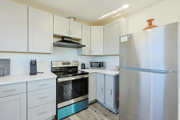 a kitchen with stainless steel appliances white cabinets and white appliances