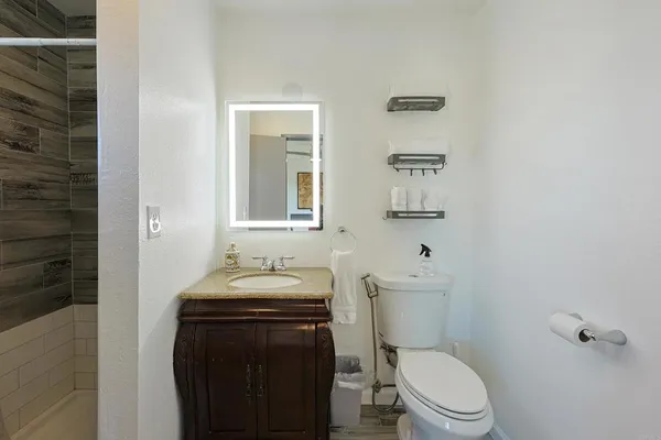 a bathroom with a sink a toilet and mirror