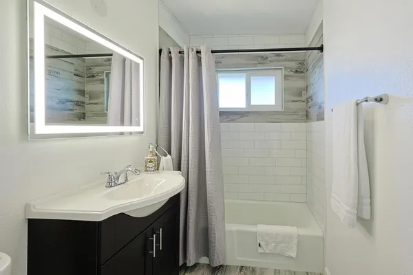 a bathroom with a shower sink and mirror
