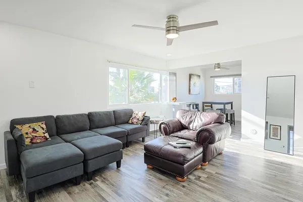 a living room with furniture and a wooden floor