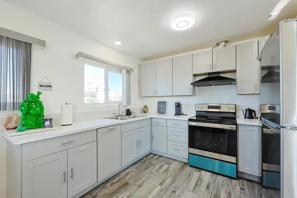 a kitchen with white cabinets appliances and a sink