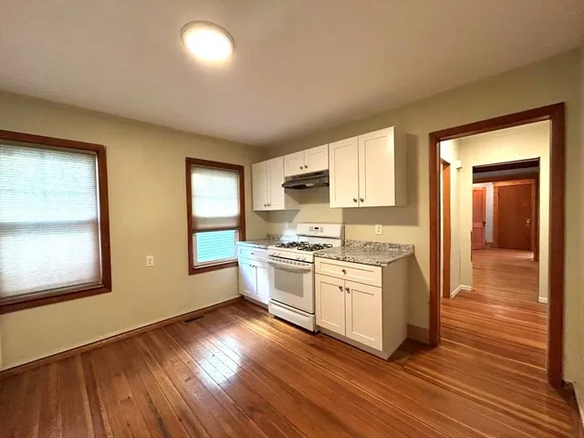 a kitchen with stainless steel appliances granite countertop a stove and a wooden floors
