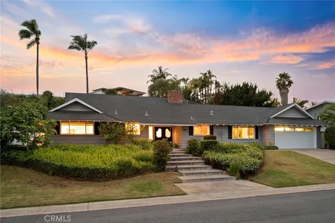 a view of a large house with a big yard and potted plants