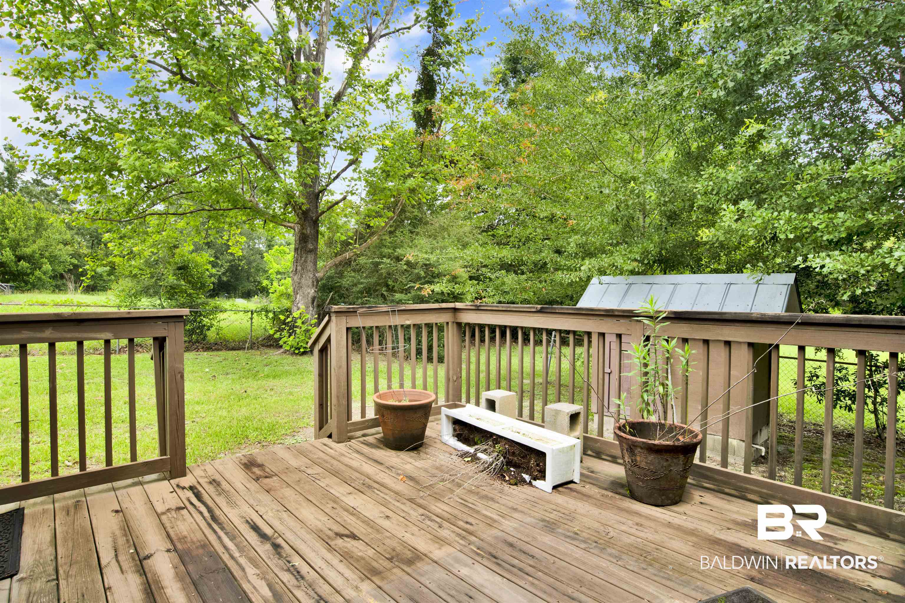 17714 Horseneck Road Bay Minette, AL 36507 - Photo 28 of 36 Wood-finish deck with railing overlooking a grassy yard with mature trees