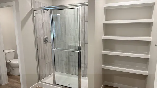 a white toilet sitting next to a shower