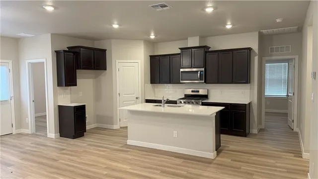 a kitchen with stainless steel appliances granite countertop a refrigerator stove microwave and sink