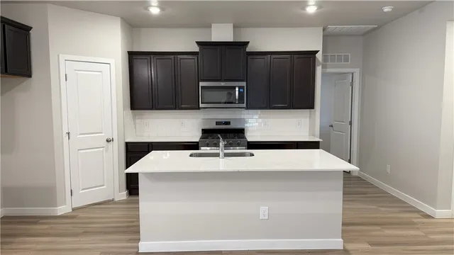 a kitchen with kitchen island white cabinets and stainless steel appliances