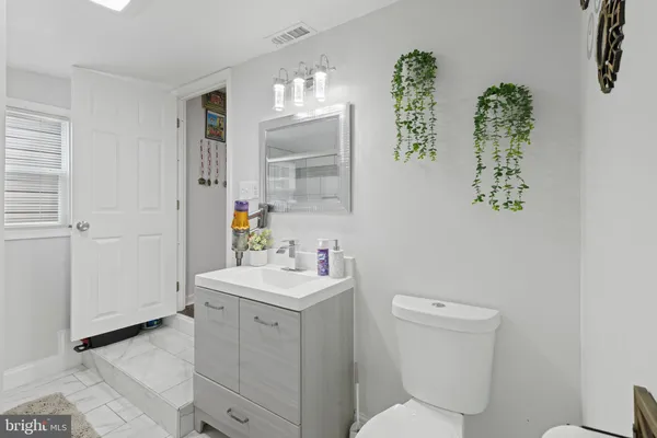 a bathroom with a toilet sink and mirror