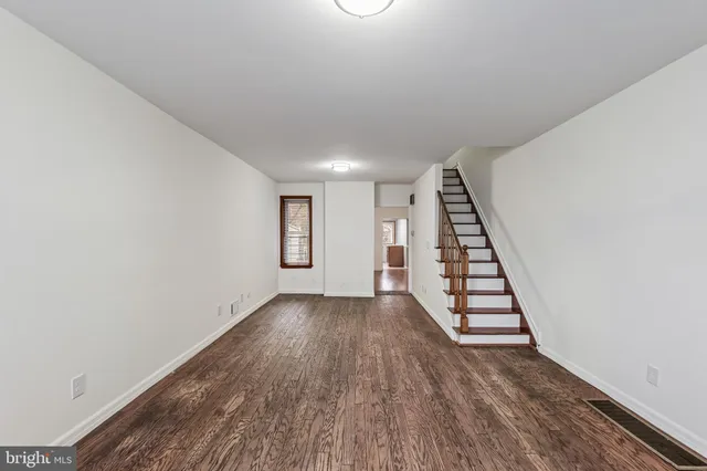 a view of a room with wooden floor and window