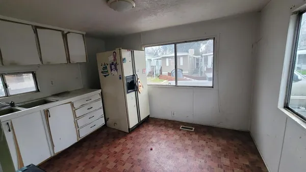 a view of a kitchen with refrigerator and window