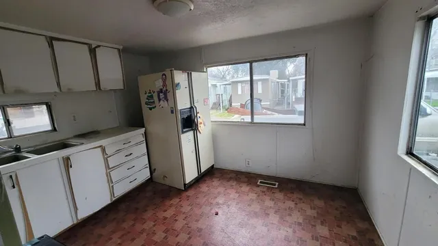 a view of a kitchen with refrigerator and window