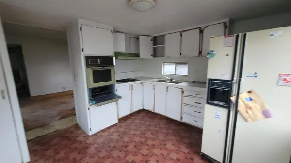 a kitchen with white cabinets and white appliances
