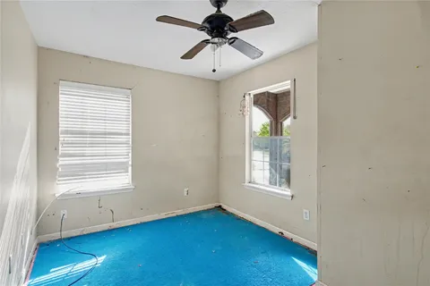 a view of an empty room with a window and a dresser