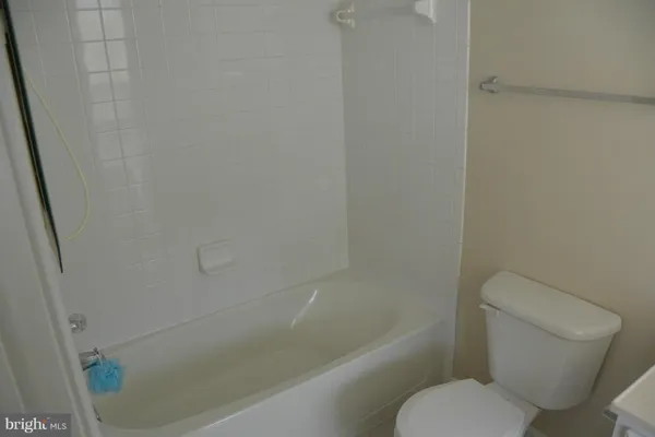 a white toilet sitting next to a bath tub