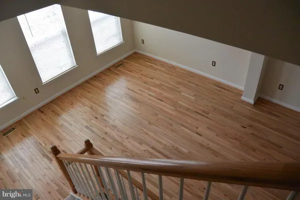 a view of a room with wooden floor and white walls