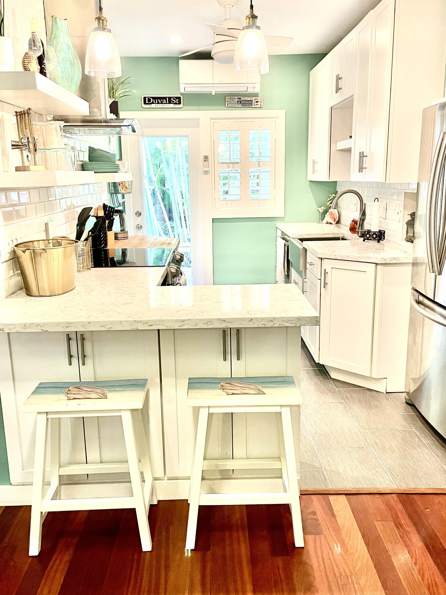804 South Street, Unit 1 Key West, FL 33040 - Photo 14 of 31 a view of kitchen with stainless steel appliances granite countertop a stove a sink and white cabinets with wooden floor