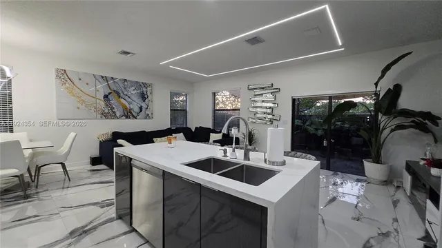 a kitchen with a sink a table and chairs