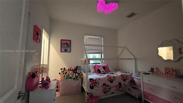 a bedroom with bed and a chandelier