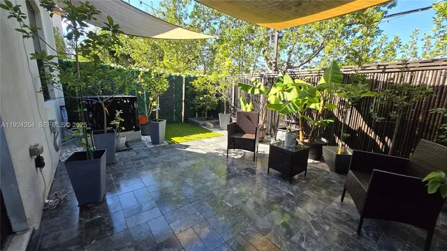 a living room with patio furniture and a potted plants