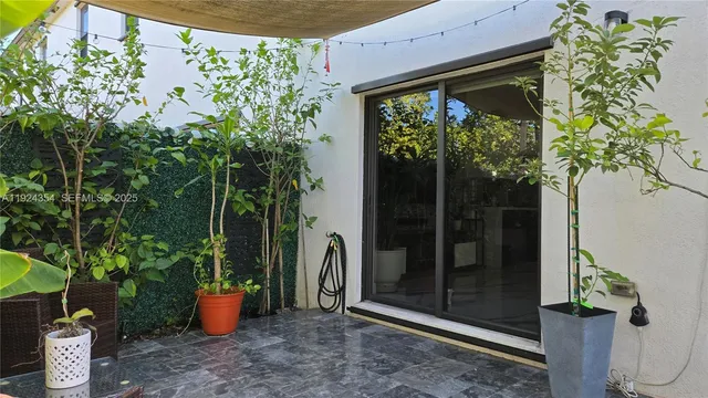 a front view of a house with a garden and tree
