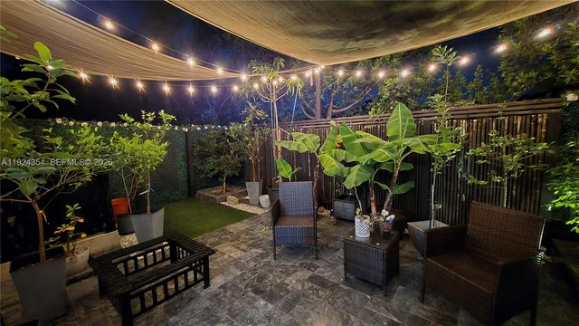 a living room with patio furniture and a potted plants