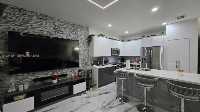 a kitchen with stainless steel appliances a stove sink microwave and refrigerator