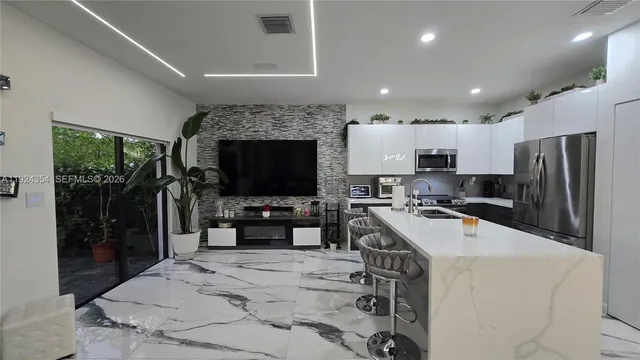 a kitchen with stainless steel appliances a stove sink microwave and refrigerator