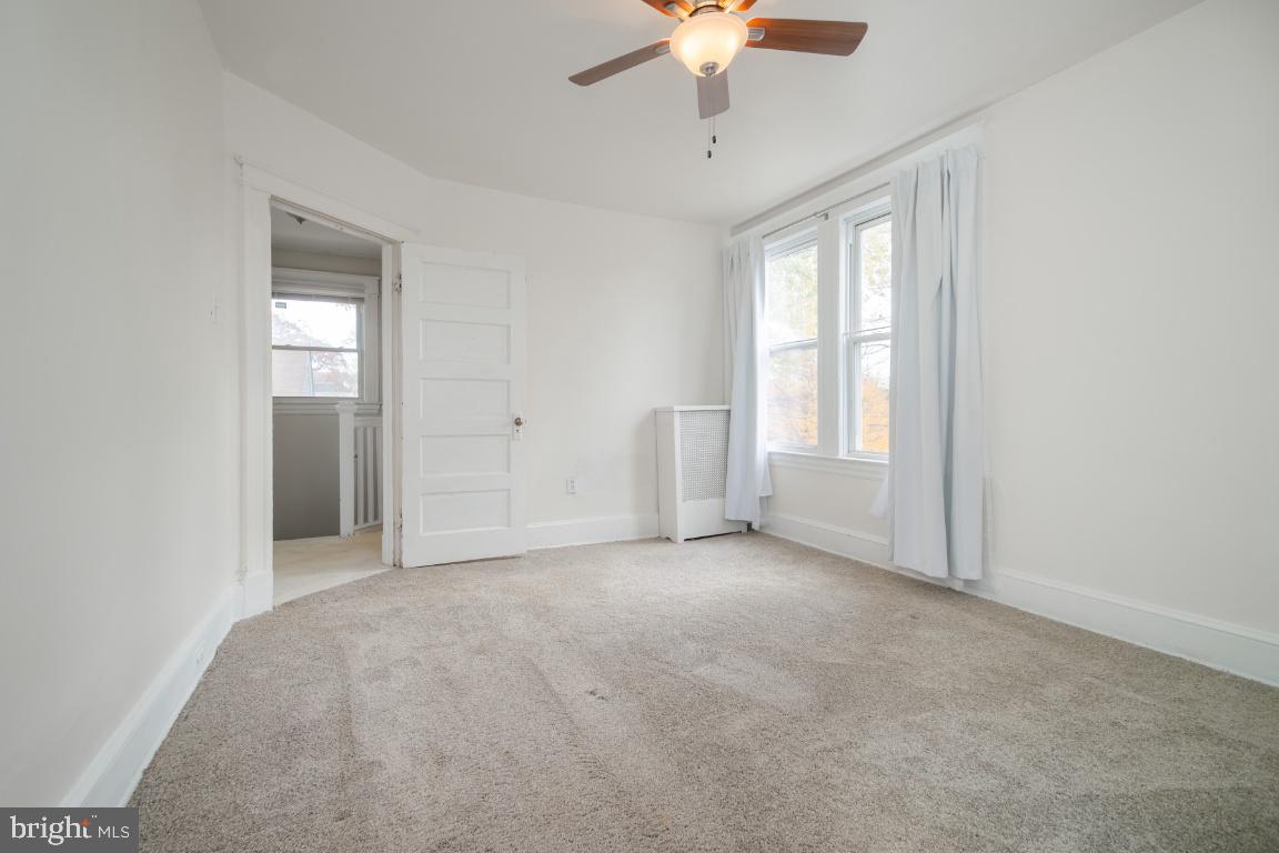 3312 Glen Avenue Baltimore, MD 21215 - Photo 16 of 25 an empty room with chandelier fan and windows