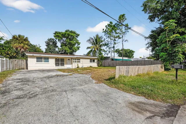a view of a yard in front of a house with a large tree