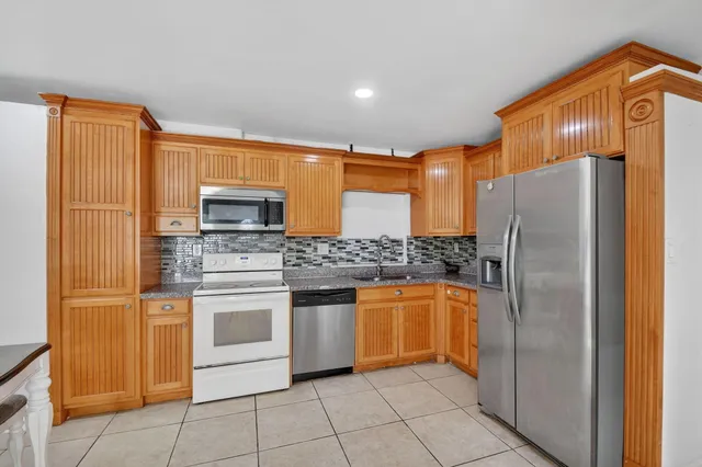 a kitchen with stainless steel appliances granite countertop a sink and a stove